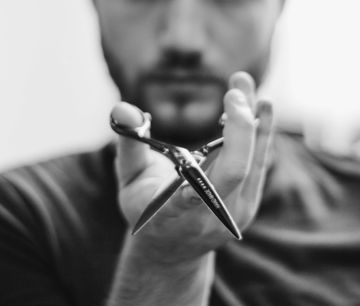shallow-focus-photo-of-man-holding-scissors.jpg shallow focus photo of man holding scissors